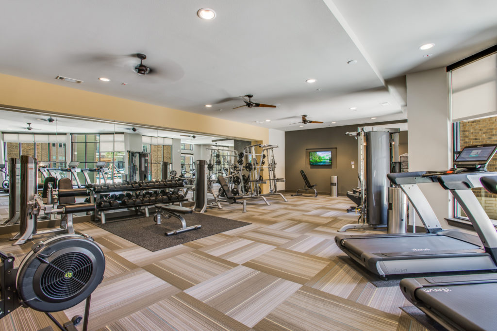 Fitness center with cardio machines, strength training equipment, and free weights