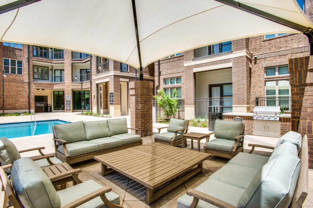 Large poolside gazebo with comfortable couches and table