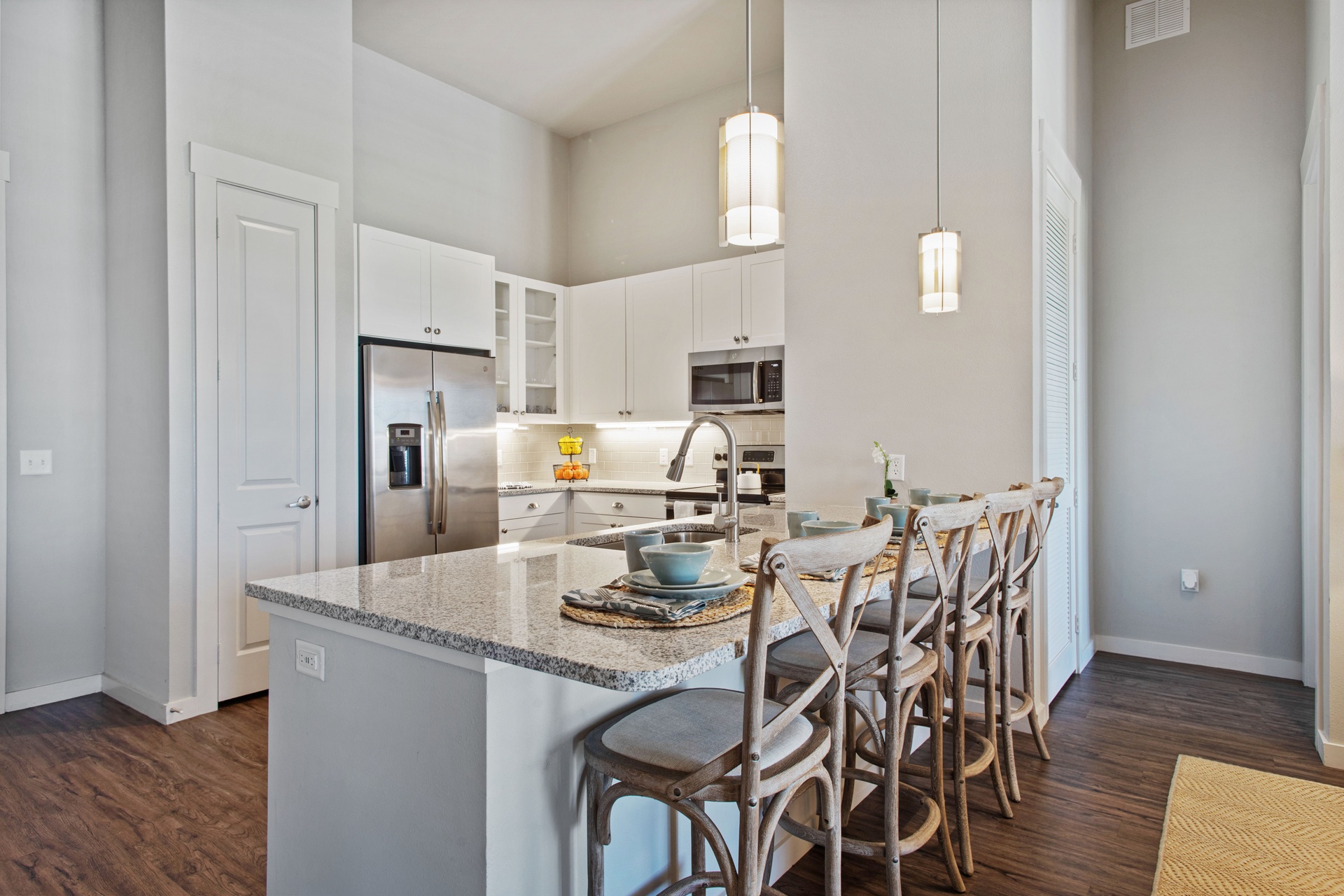 fourteen-foot ceilings interior unit overlooking kitchen with white cabinetry and stainless steel appliances